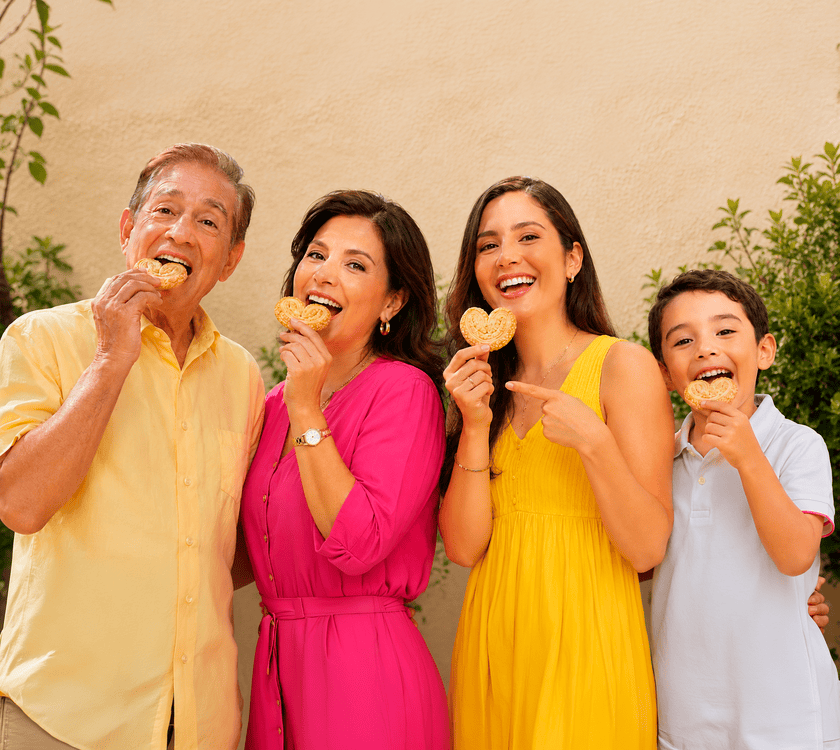 Una familia de tres generaciones ríe mientras comparte orejitas.