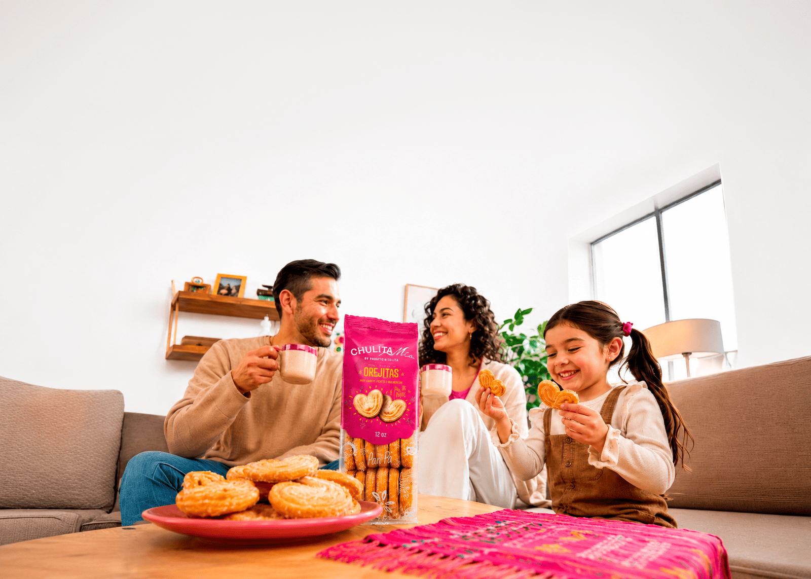 Una familia comparte orejitas Chulita Mía y café en la sala de su casa.